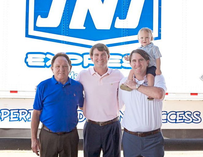 Three generations of the JNJ Express family in front of a company trailer